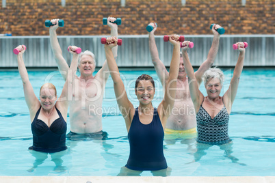 Female instructor with senior swimmers exercising in swimming pool