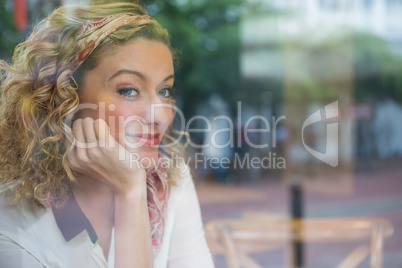 Portrait of beautiful woman with hand on chin in coffee shop