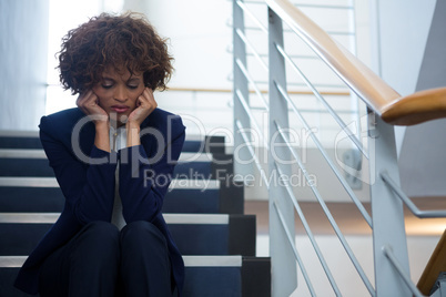 Worried businesswoman sitting on steps