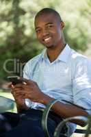 Happy man using mobile phone at outdoor restaurant