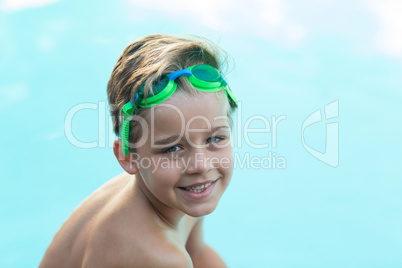 Smiling little boy wearing green swimming goggles