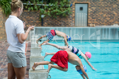 Female instructor monitoring time at poolside