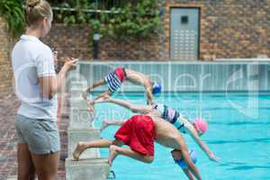 Female instructor monitoring time at poolside