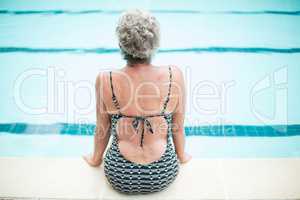 Senior woman sitting on poolside