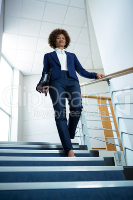 Businesswoman with diary climbing down the stairs