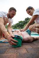 Lifeguards pressing chest of unconscious senior man