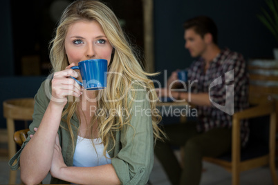 Young woman drinking coffee at cafeteria