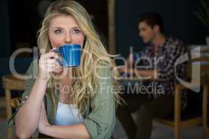 Young woman drinking coffee at cafeteria