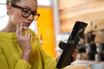 Woman using digital table in coffee shop