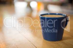 Coffee cup on wooden table in cafeteria