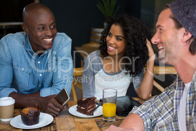 Friends talking at table in coffee house