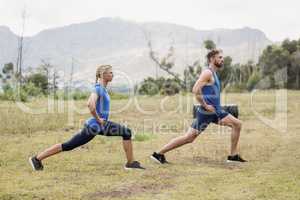 Fit man and woman exercising in boot camp