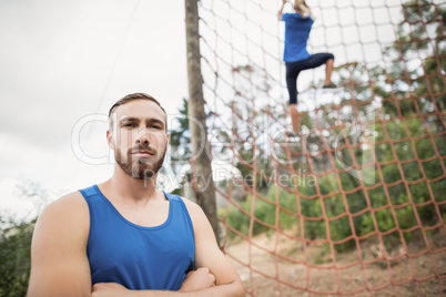 Woman climbing a net during obstacle course