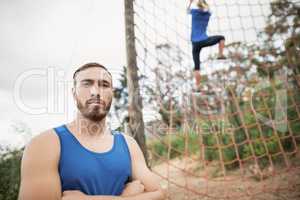 Woman climbing a net during obstacle course