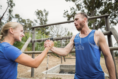 Fit man and woman greetings during obstacle course