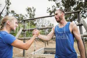 Fit man and woman greetings during obstacle course