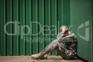 Frustrated military soldier sitting with hands on head