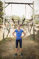 Portrait of woman standing with her hands on hip during obstacle course