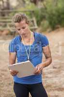Female trainer holding clipboard during obstacle course
