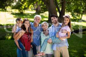 Smiling family posing together in park