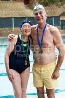Cheerful senior couple standing at poolside