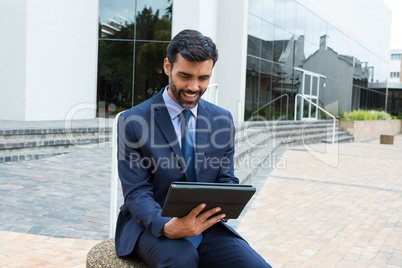 Smiling businessman using digital tablet