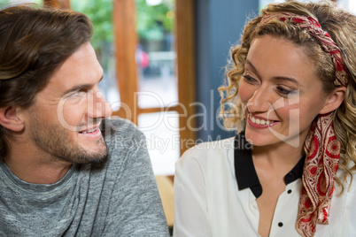 Smiling couple looking at each other in coffee shop