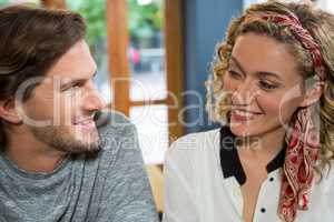 Smiling couple looking at each other in coffee shop