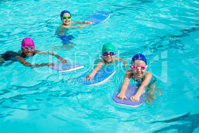 Little swimmers with kickboards enjoying in pool
