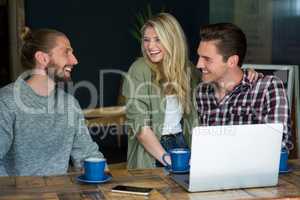 Cheerful male and female friends talking in coffee shop