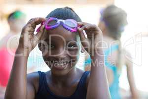 Portrait of smiling girl holding swimming goggles