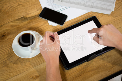 High angle view of man hands using tablet computer at table
