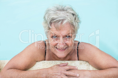 Senior woman leaning on poolside