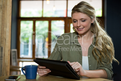 Beautiful woman using digital tablet in cafe