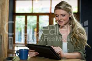 Beautiful woman using digital tablet in cafe