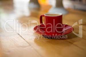 Red cup and saucer on table in coffee house