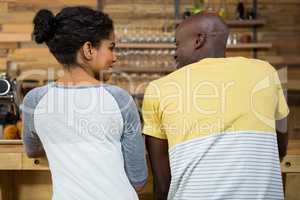 Rear view of couple looking at each other in coffee shop