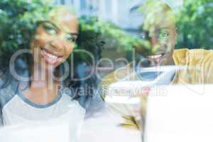 Happy young couple in coffee house seen through window