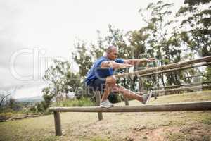 Fit man balancing on hurdles during obstacle course training