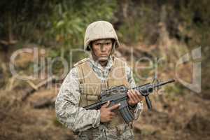 Military soldier guarding with a rifle in a boot camp