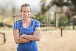 Portrait of smiling woman standing with arms crossed in during obstacle course