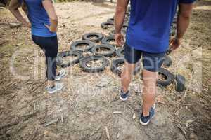 Man and woman standing near tyre during obstacle course