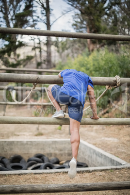 Man crossing the rope during obstacle course