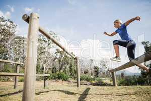 Woman jumping over the hurdles during obstacle course