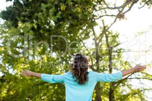 Woman standing with arms wide open in the park