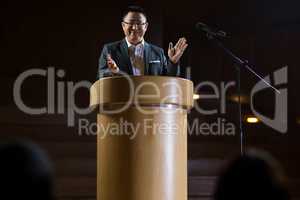 Business executive clapping while giving a speech