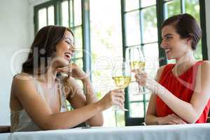 Smiling woman toasting wine glasses in restaurant