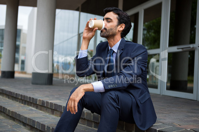 Businessman drinking coffee from disposable cup