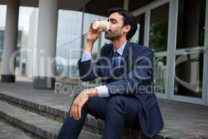 Businessman drinking coffee from disposable cup