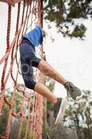 Woman climbing a net during obstacle course